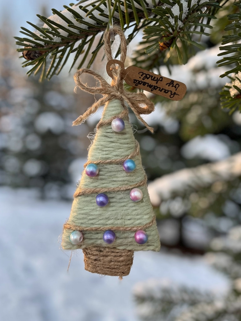 Decorative Christmas tree ornament with lights on a branch with snow in the background