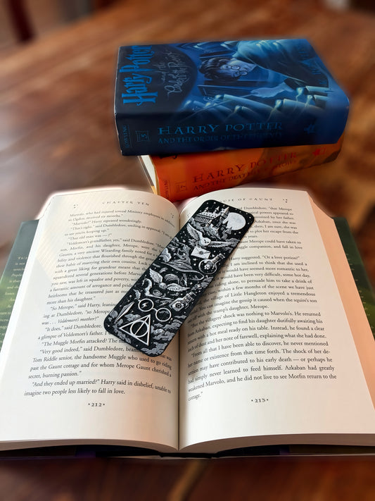 Black and white Harry Potter inspired 6.25 by 2 inch bookmark featuring Hogwarts style castle, owls, magical symbols and Deathly Hallows design displayed in an open book