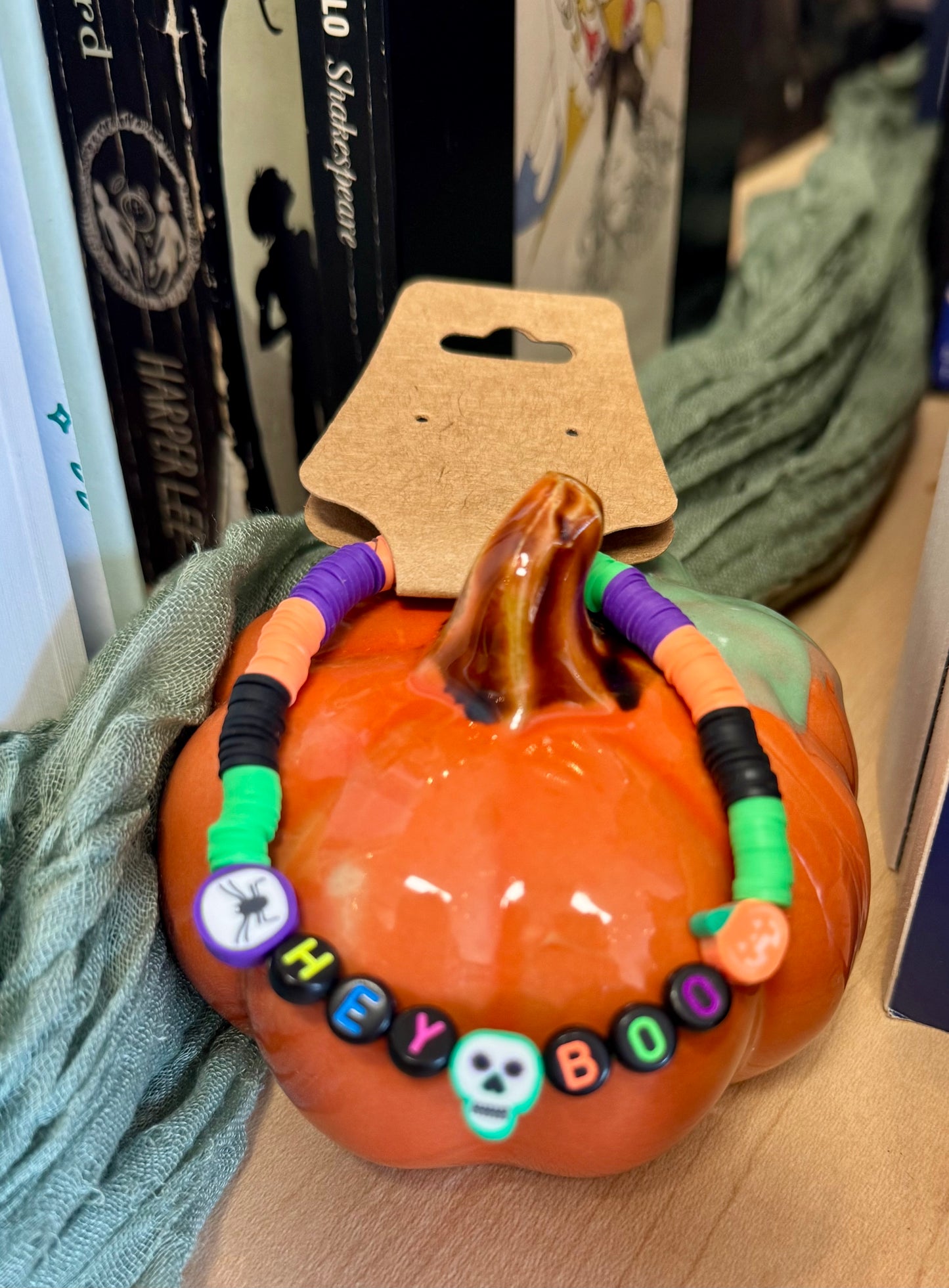 Pumpkin-shaped toy with colorful beaded necklace on a cardboard stand