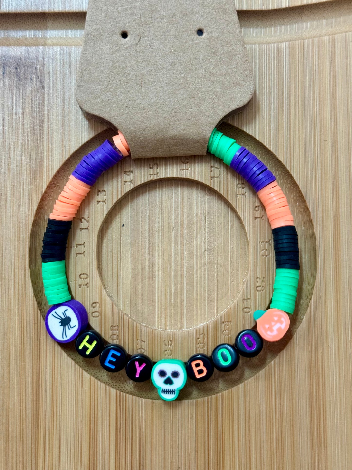 Colorful beaded bracelet with letter beads on a wooden surface