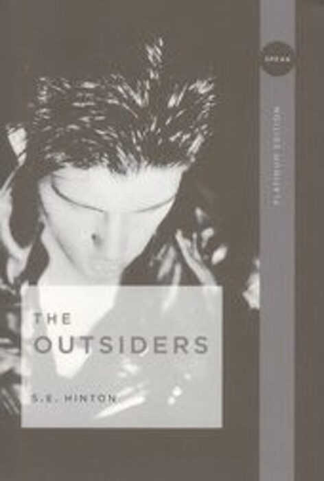 Front cover of The Outsiders by S.E. Hinton, featuring a black leather jacket with bold lettering and a gritty, urban backdrop.