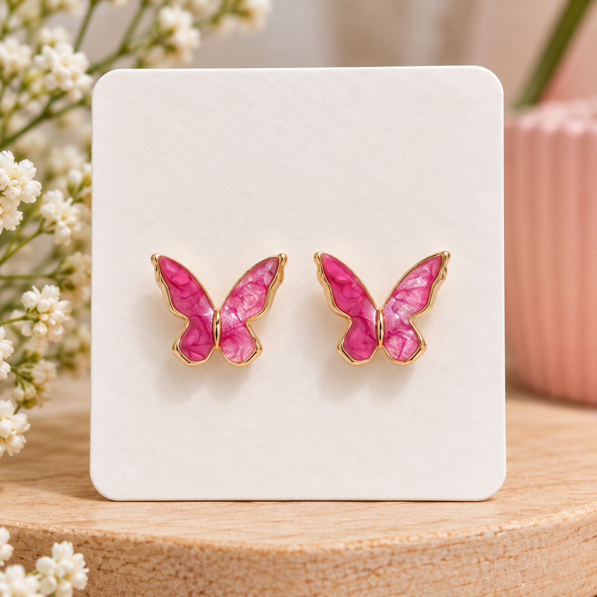Hot pink butterfly stud earrings with pearly marbled wings and gold-tone trim