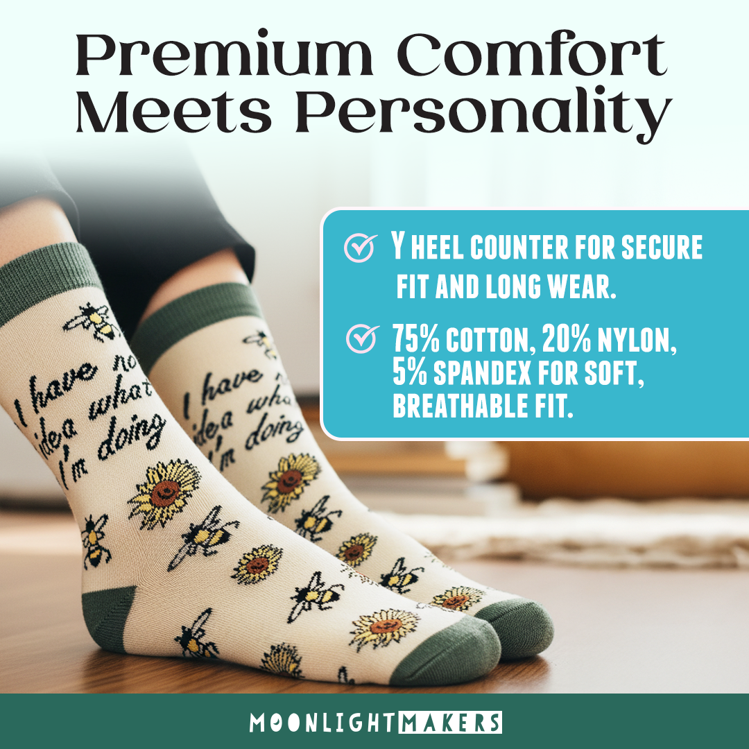 Lifestyle image of I have no idea what I’m doing novelty crew socks with bee and sunflower pattern in soft yellow and green, worn indoors on a wood floor with overlay text about Y heel counter and cotton, nylon, spandex blend, Moonlight Makers branding visible.