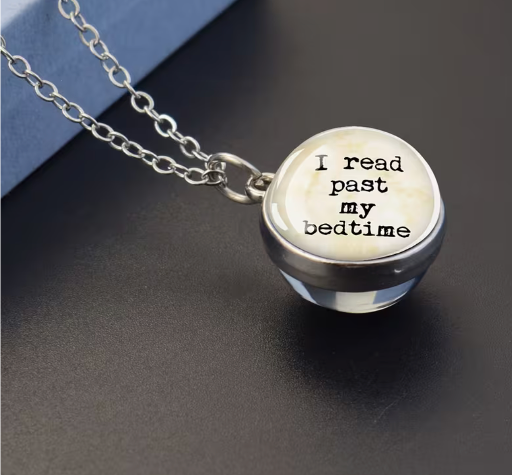 Silver-tone glass pendant necklace featuring the phrase I Read Past My Bedtime for book lovers and avid readers.