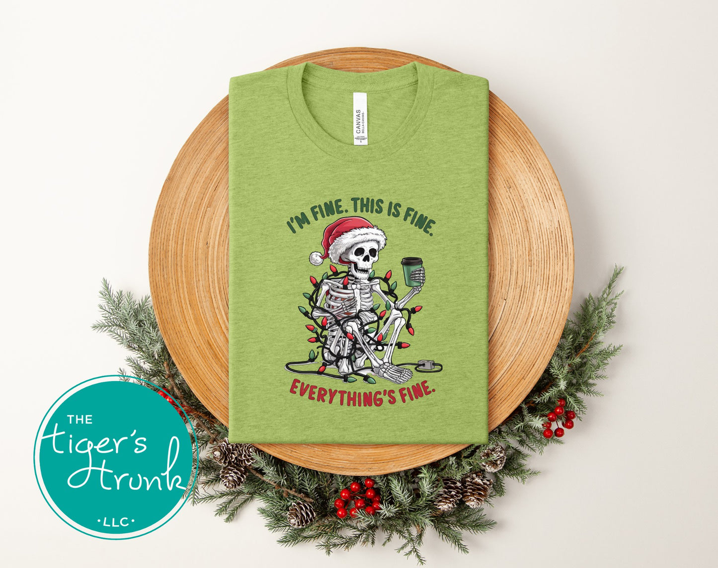 Green heather Christmas shirt with skeleton in Santa hat wrapped in lights and text I’m Fine This Is Fine Everything’s Fine.