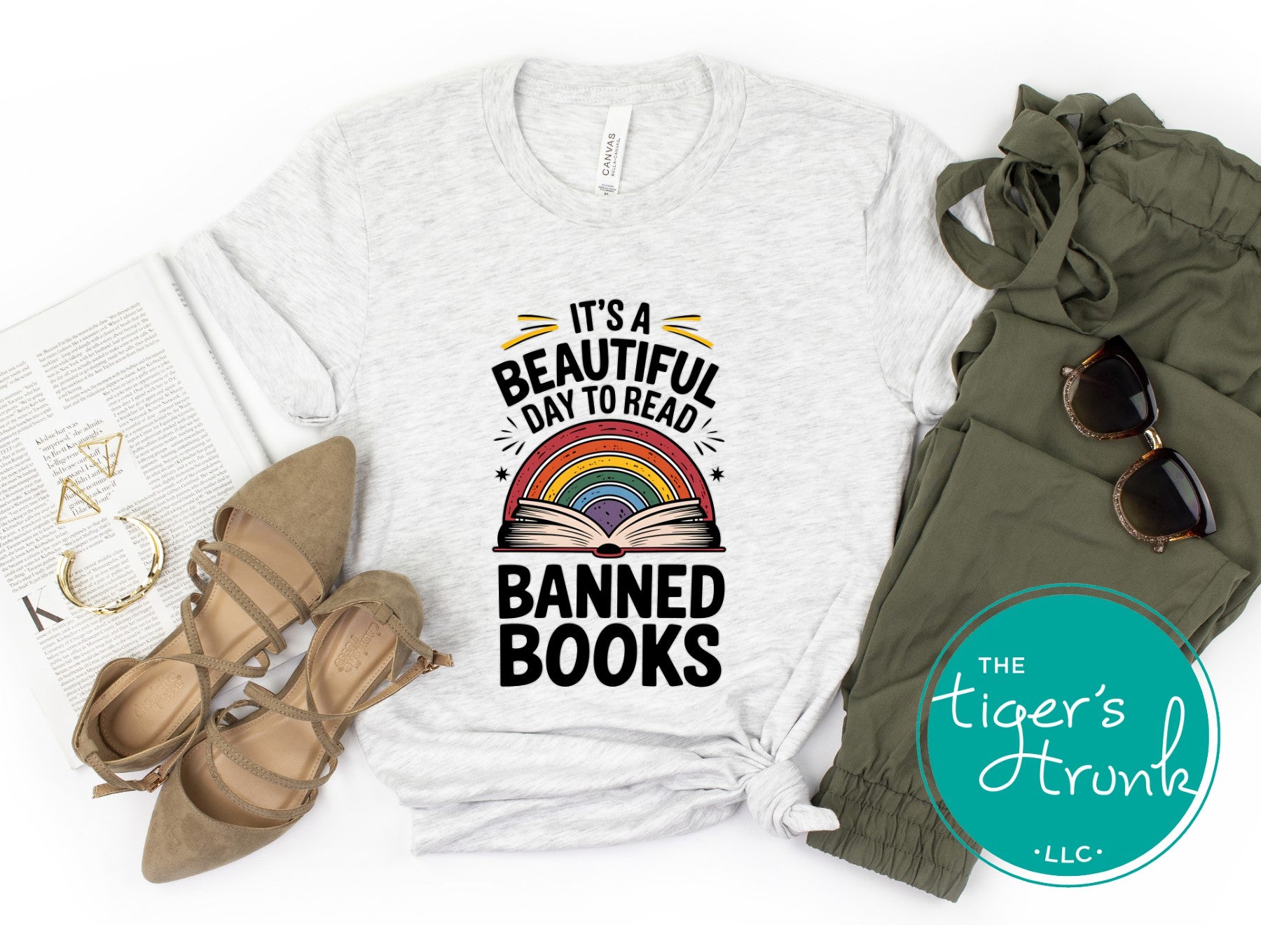 White t-shirt with 'Banned Books' graphic, green pants, sunglasses, and shoes on a white background.