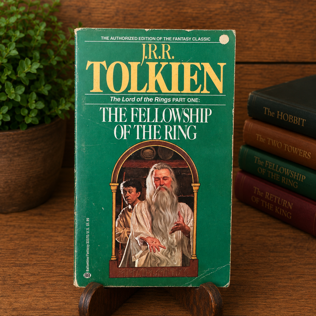 Vintage The Fellowship of the Ring by J.R.R. Tolkien, Ballantine Books paperback, displayed upright on a wooden stand with a warm bookshelf backdrop. The green cover retains its authentic fair-condition wear, including edge wear, corner rubbing, surface creases, a small circular hole punch near the upper-right corner, and a light crease near the lower-right corner.