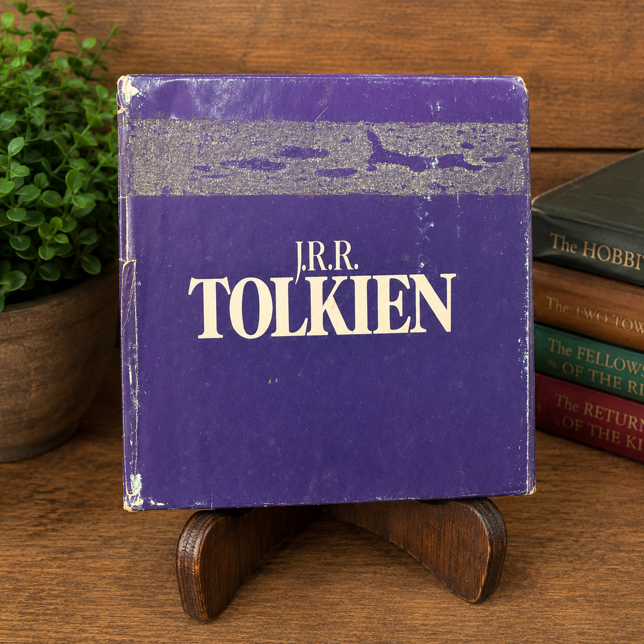 Top of the original purple Del Rey Fantasy slipcase for the vintage J.R.R. Tolkien The Hobbit and The Lord of the Rings four-book paperback boxed set. The top panel features the J.R.R. Tolkien logo and shows authentic fair-condition wear, including a large rubbed area, scuffed edges, corner wear, and surface scratches.