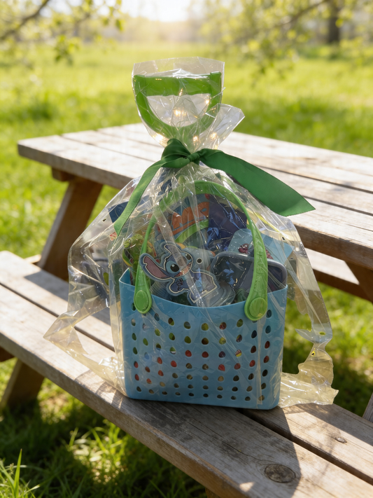 Kids summer beach gift basket in blue tote bag filled with toys and Finding Nemo book wrapped with ribbon outdoors