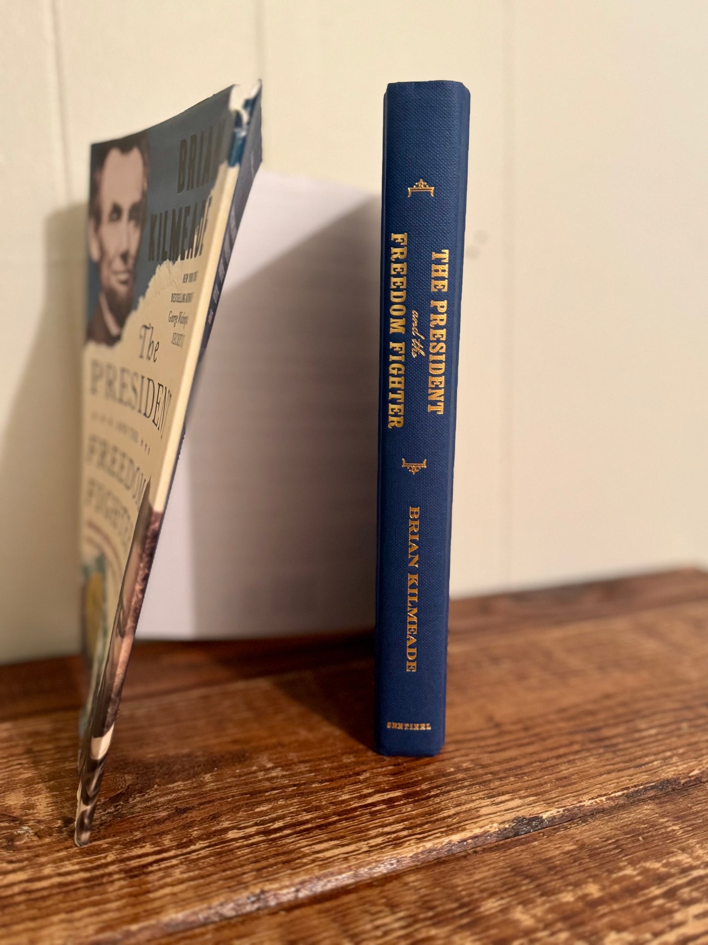 Blue book titled 'The President as a Freedom Fighter' on a wooden surface with a blurred background