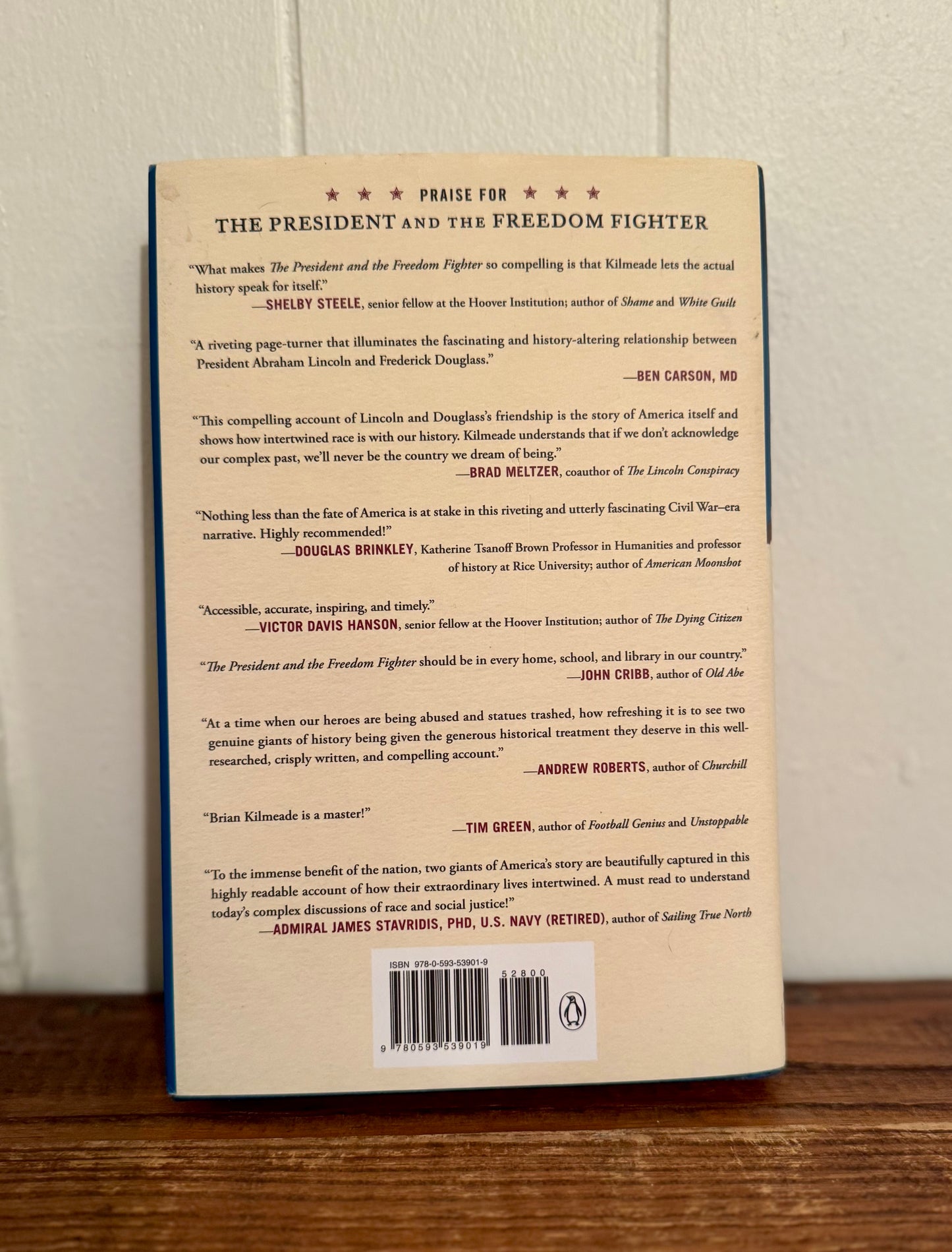 Back cover of a book with text and a barcode on a wooden surface.