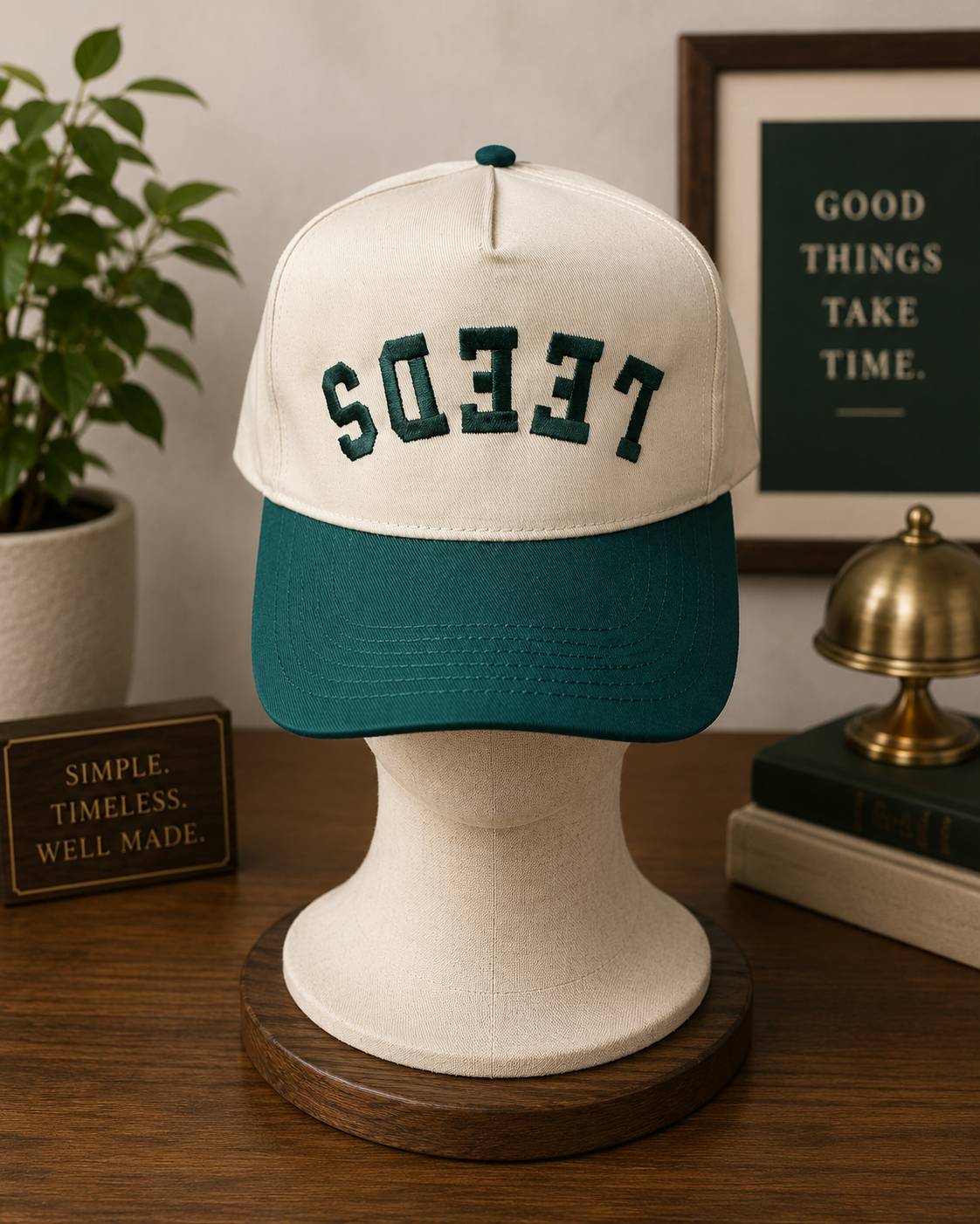 Cream and green trucker-style snapback hat featuring backwards embroidered LEEDS lettering in dark green on the front.