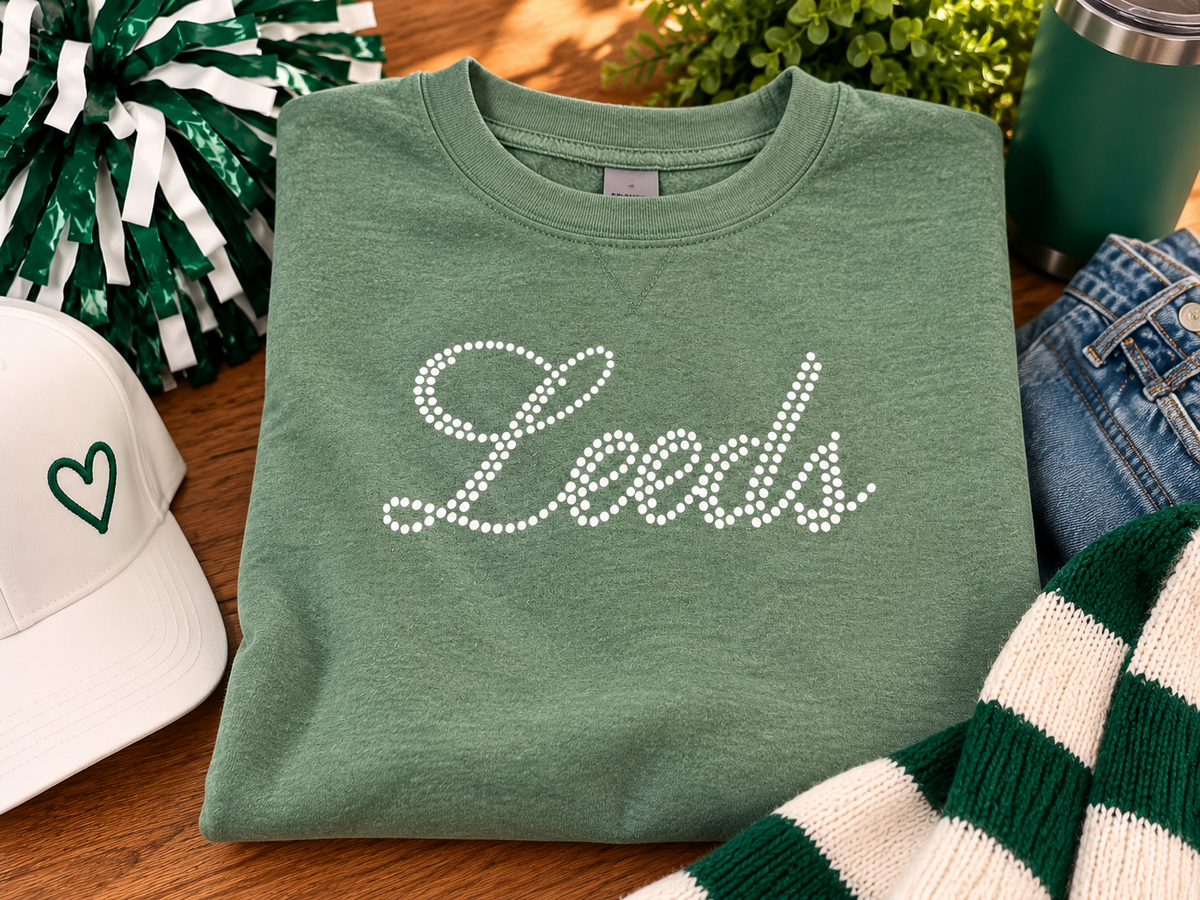 Vintage green Leeds Greenwave crewneck sweatshirt featuring white dotted Leeds script lettering, displayed with green and white school spirit accessories.