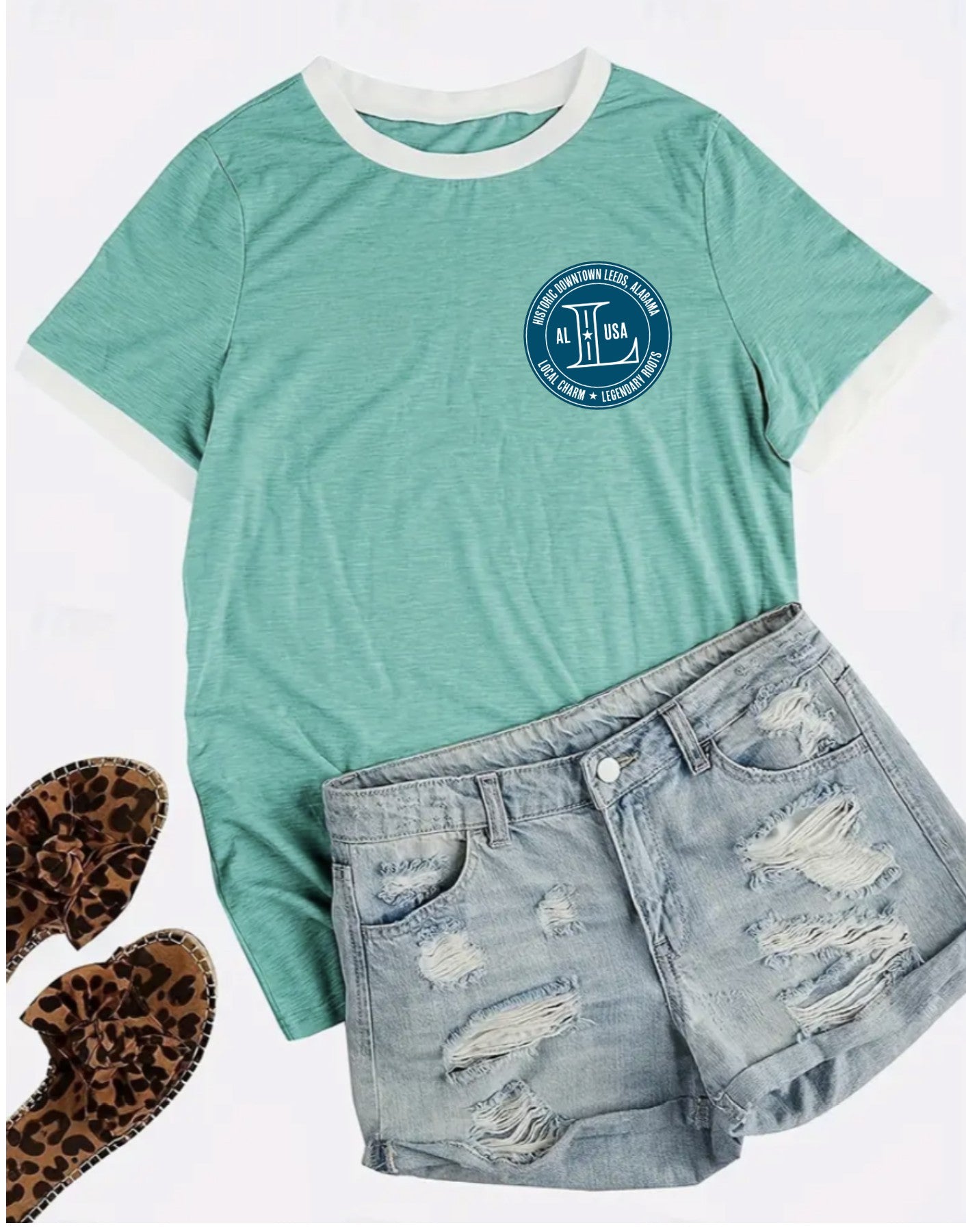 Green t-shirt with a logo, denim shorts, and leopard print shoes on a white background