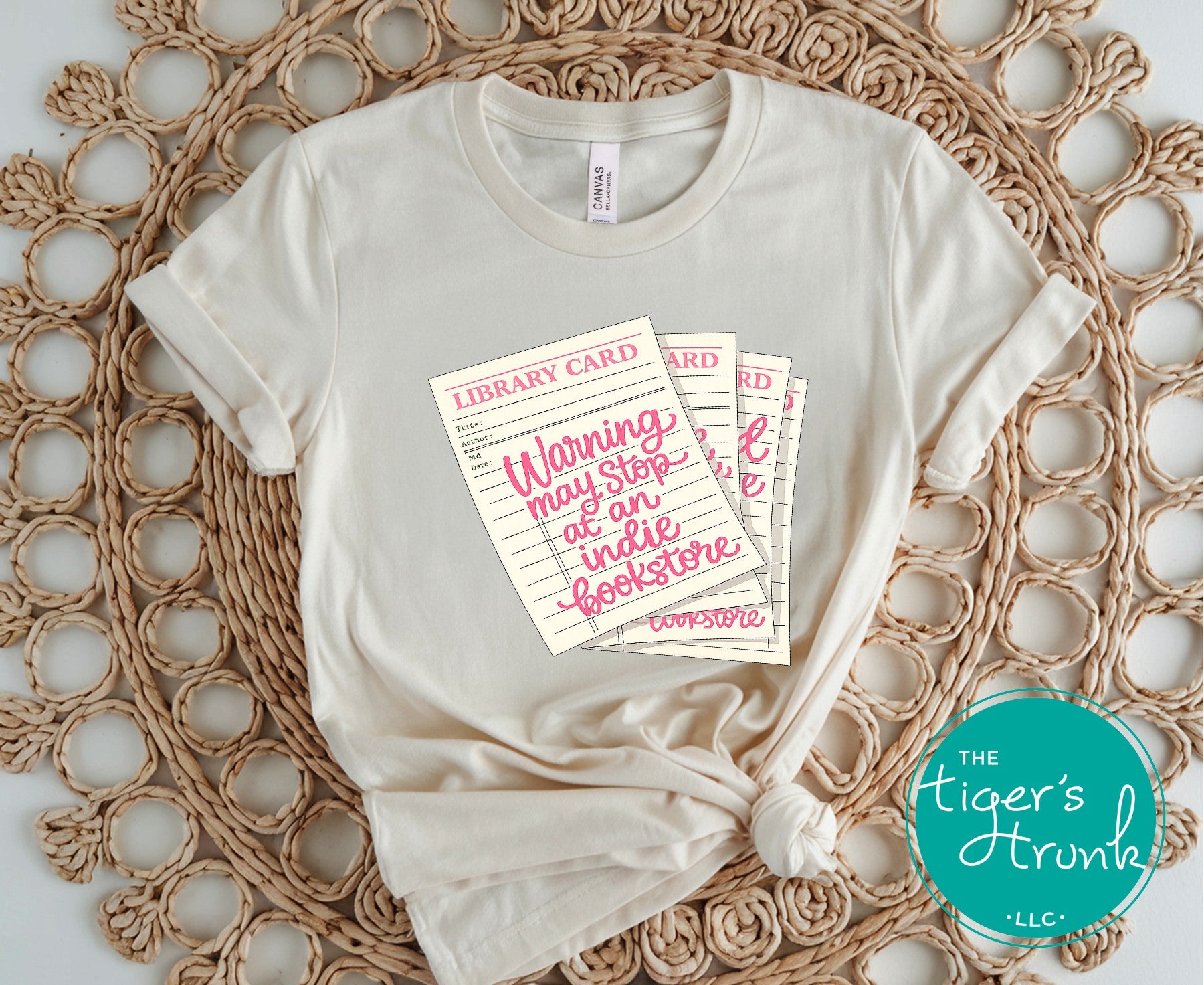 Library card shirt with warning may stop at an indie bookstore design on cream, navy, mauve, sage, sand, fatigue green, and maroon shirts
