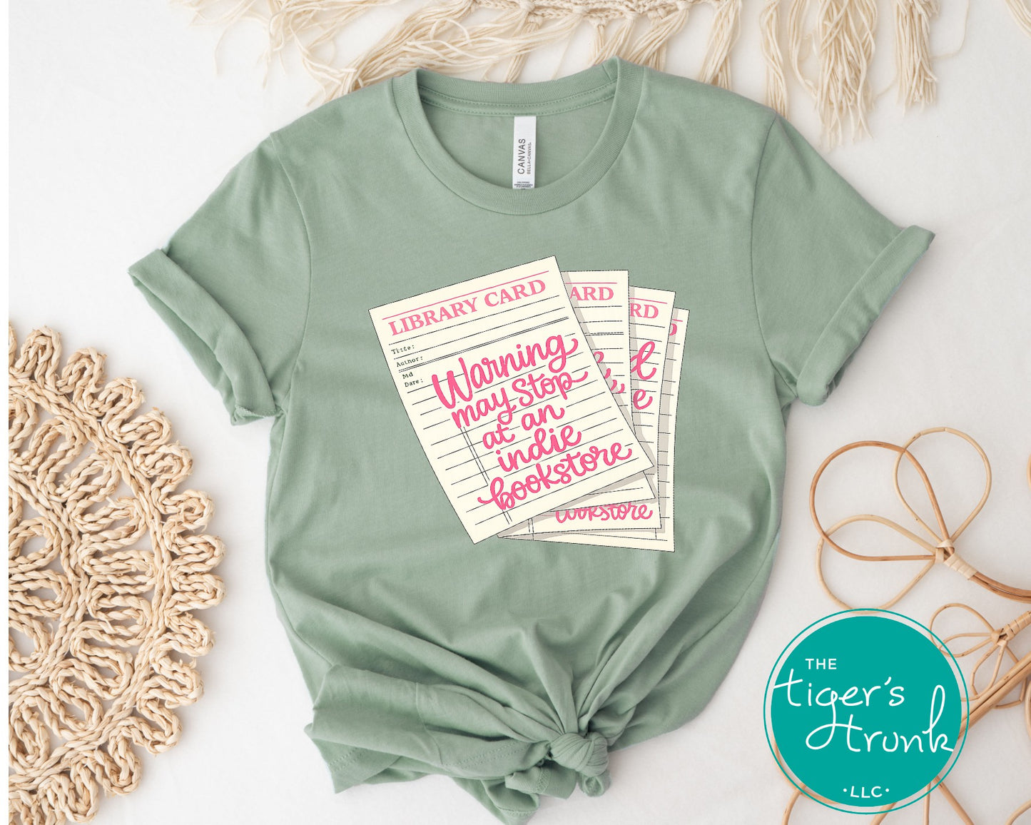 Library card shirt with warning may stop at an indie bookstore design on cream, navy, mauve, sage, sand, fatigue green, and maroon shirts