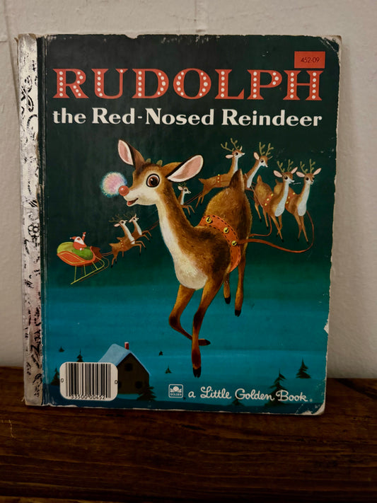 Vintage 'Rudolph the Red-Nosed Reindeer' Little Golden Book on a wooden surface.