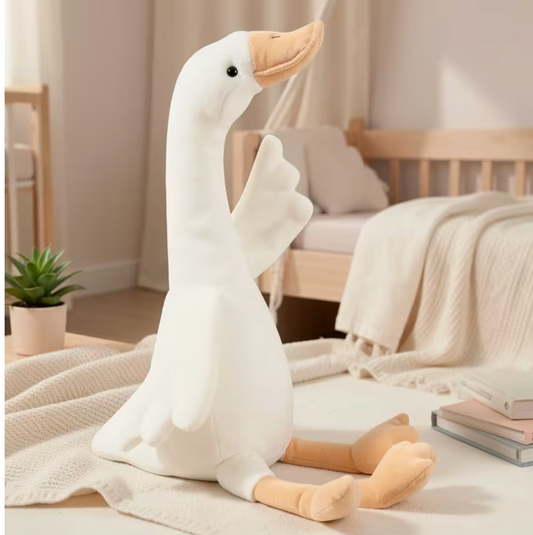 Soft long-neck goose plush sitting on a bed in a cozy bedroom reading nook.