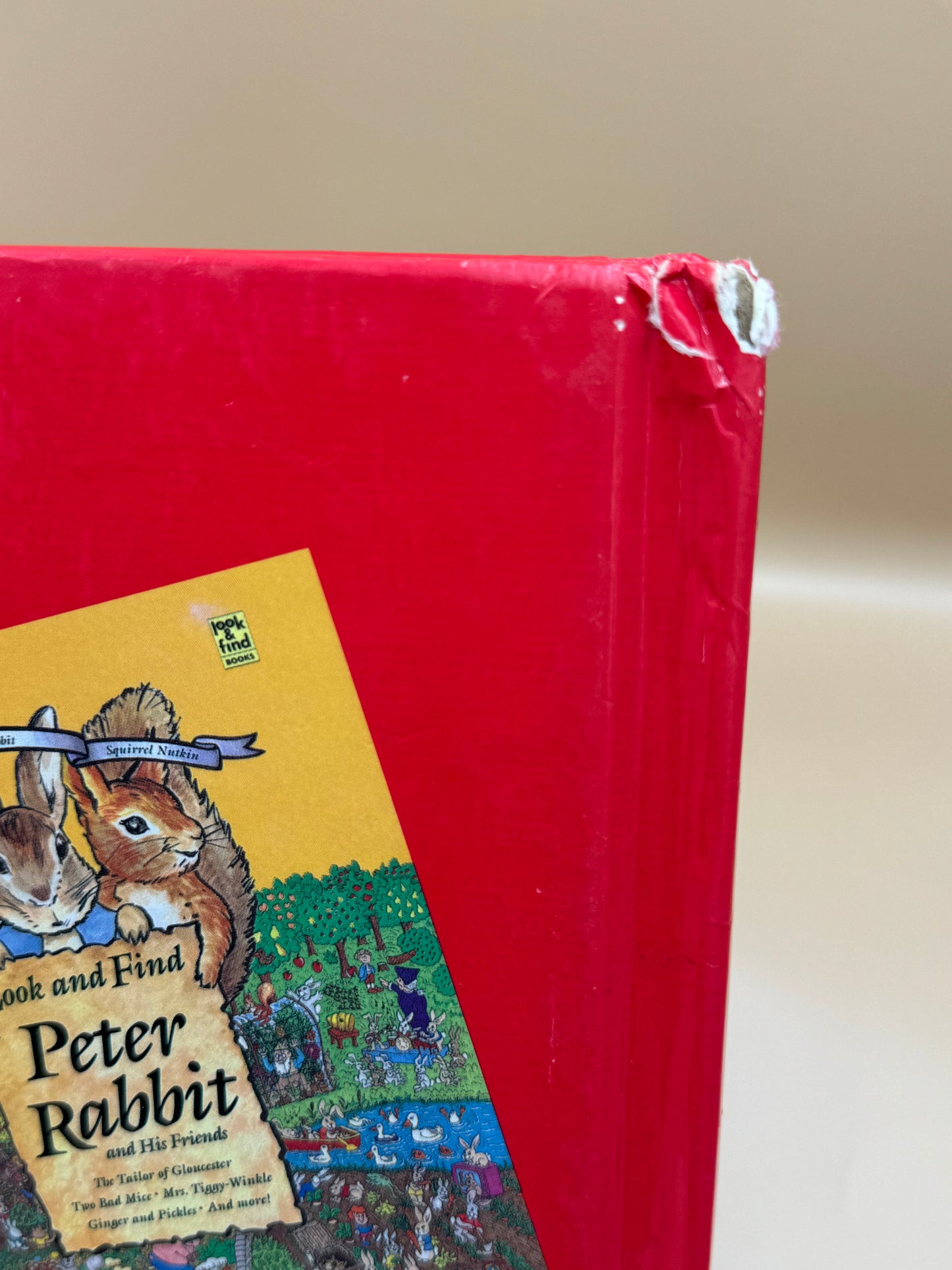 Red book with 'Peter Rabbit' illustration on a beige background
