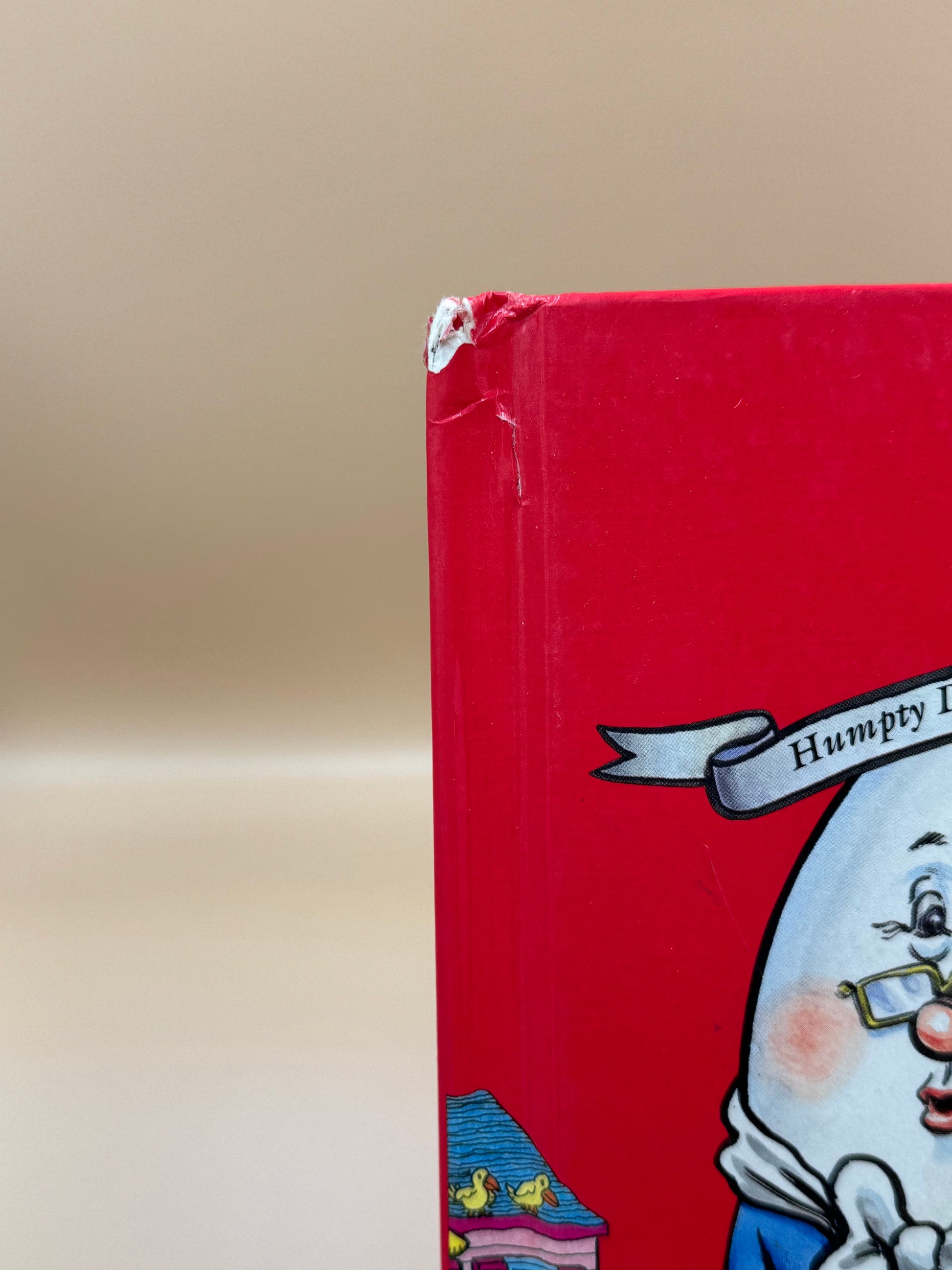 Red book with a cartoon character on the cover against a beige background