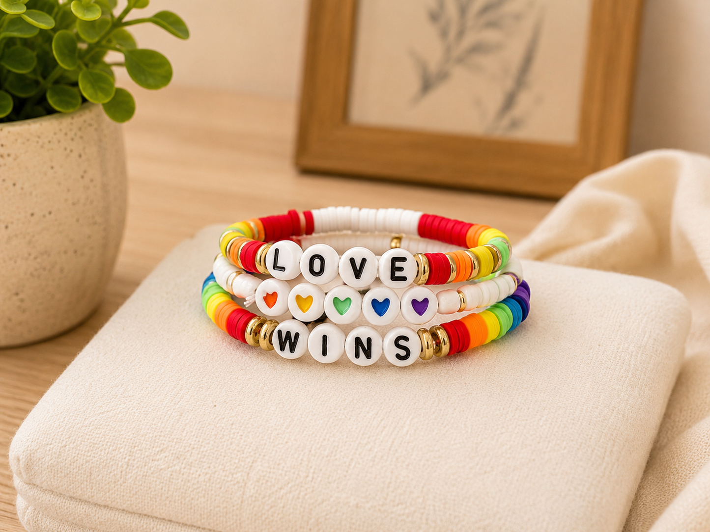 Love Wins rainbow bracelet stack with heart bead accents and colorful stretch bands