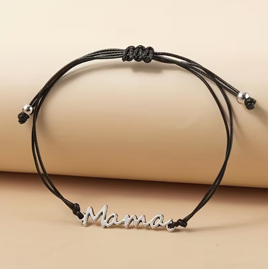 Black cord mama bracelet with silver script charm displayed flat