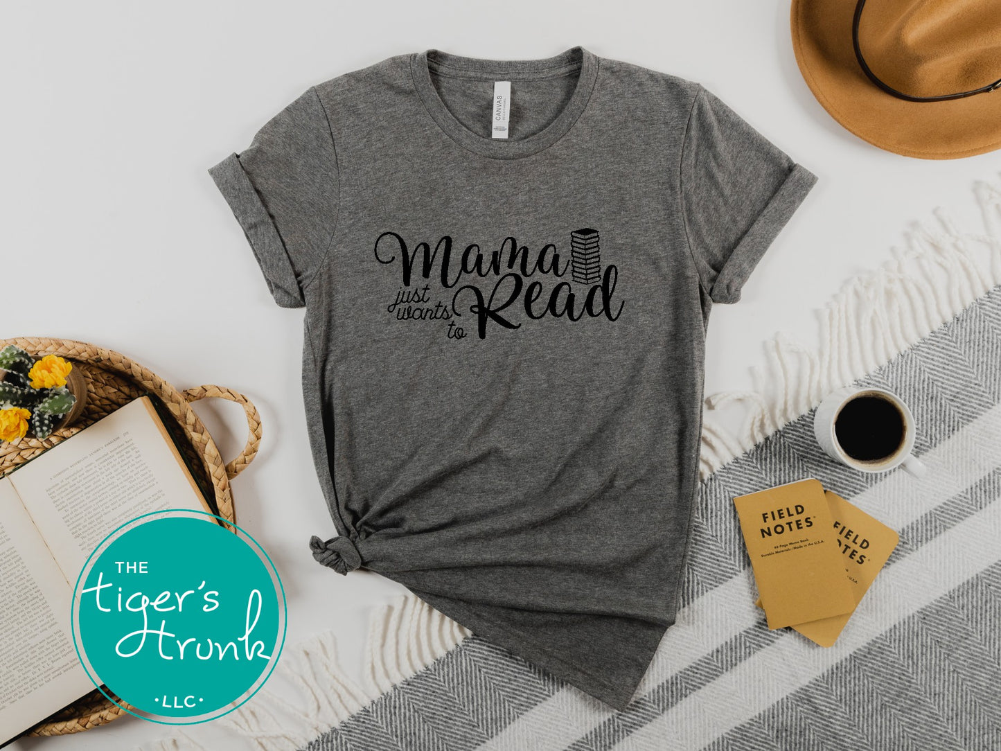 Gray t-shirt with 'Mama Just Wants to Read' text on a white surface with books and coffee.