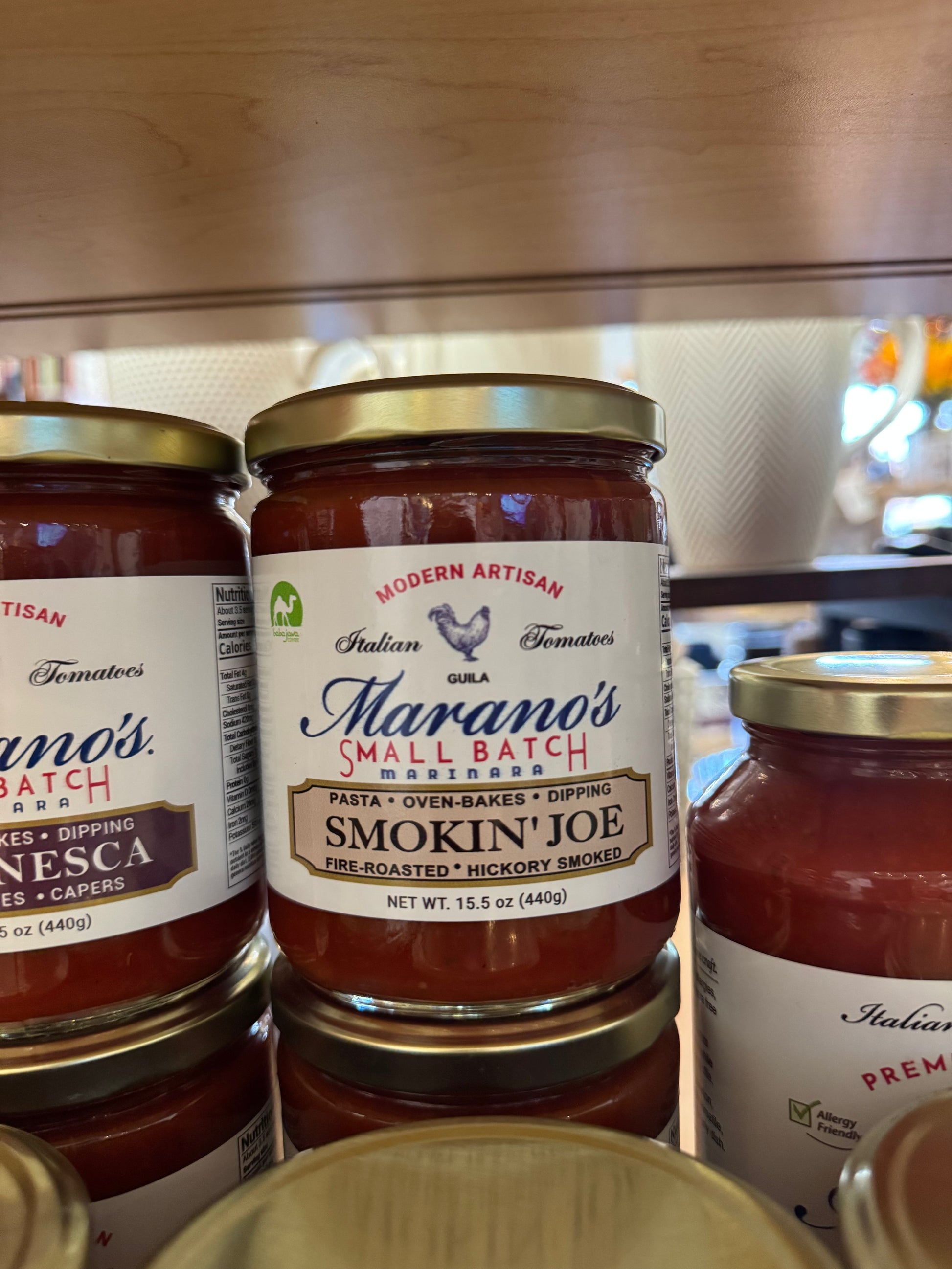 Jars of Marano's Small Batch pasta sauce on a wooden surface