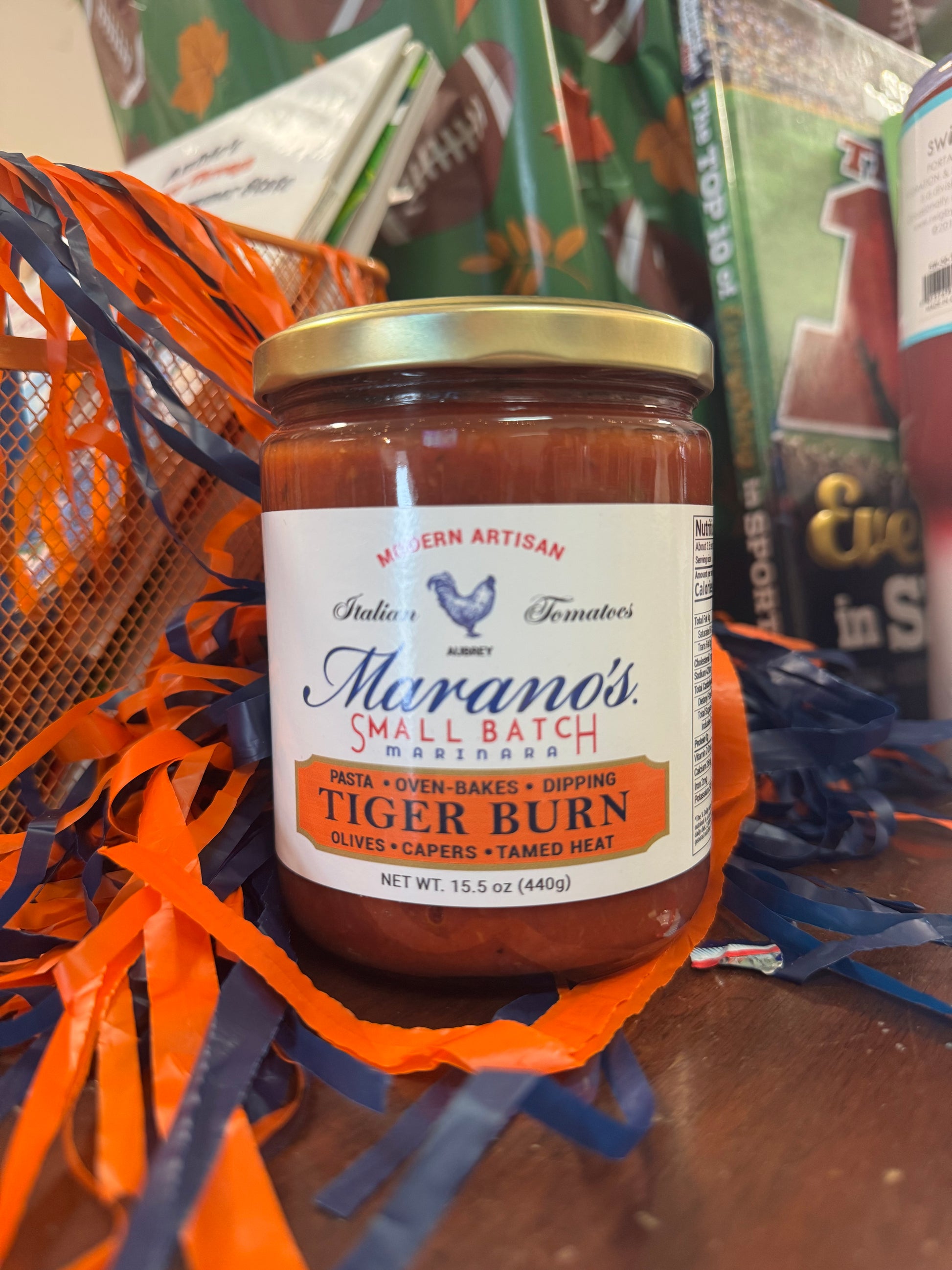 Jar of Marano's Tiger Burn sauce on a table with decorative items in the background