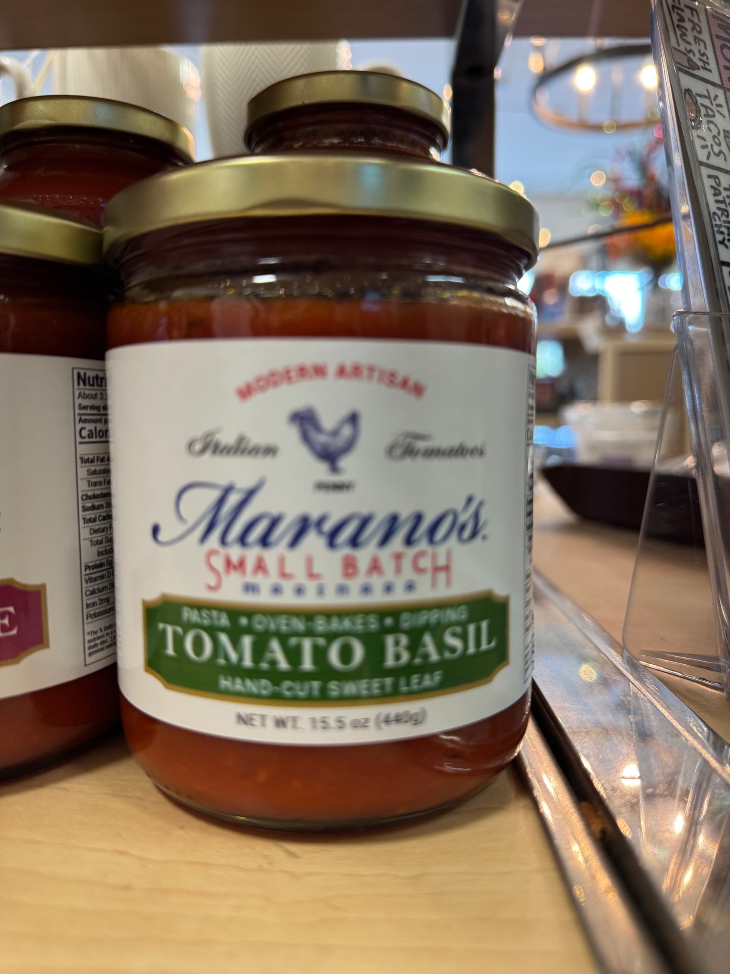 Jar of Marano's Small Batch Tomato Basil pasta sauce on a shelf.