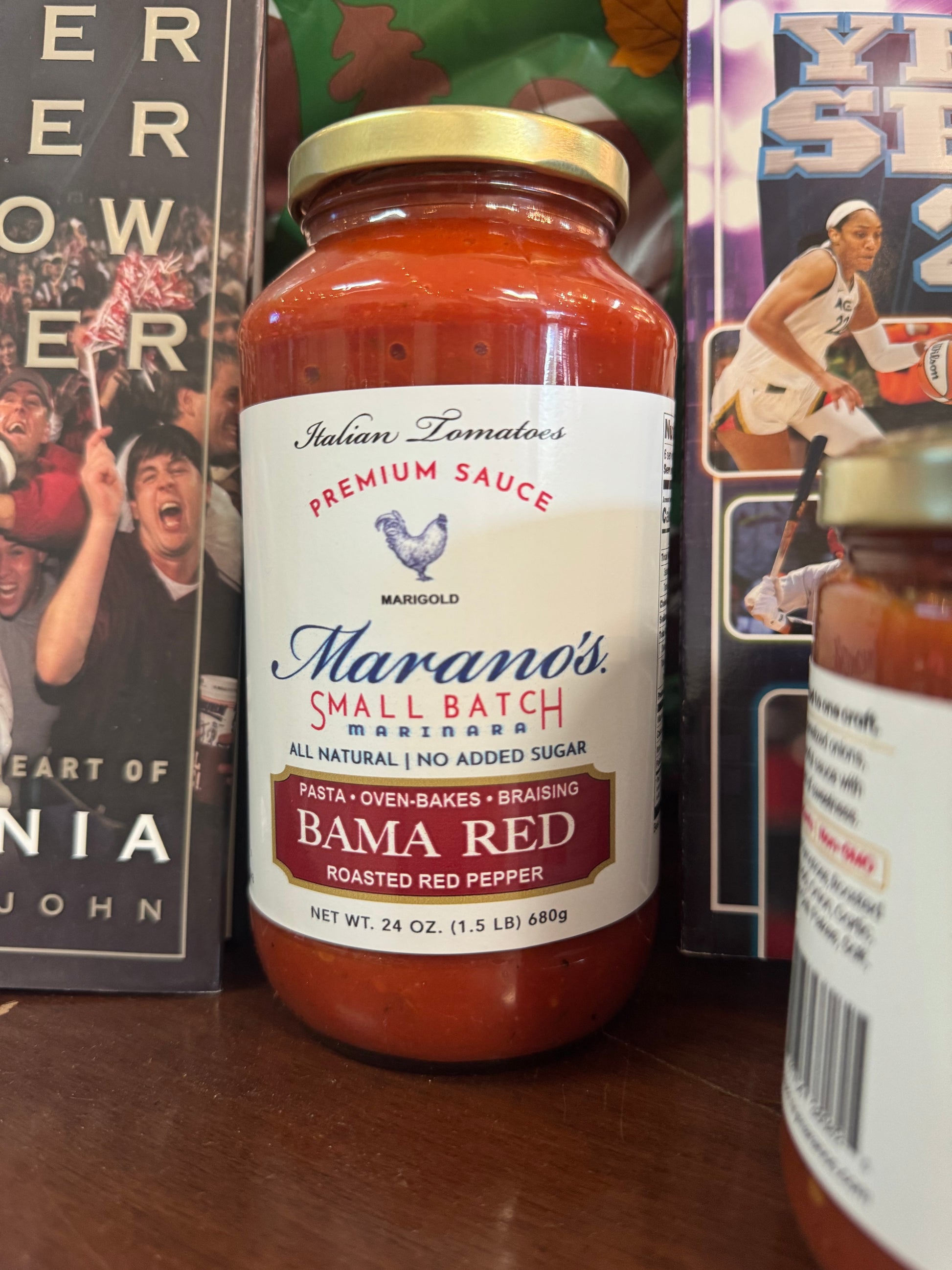 Marano's Small Batch Premium Sauce bottle on a table with sports memorabilia in the background