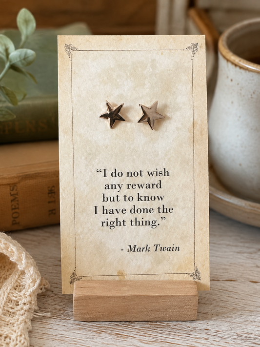 Small gold tone star stud earrings displayed on a vintage Mark Twain literary quote card