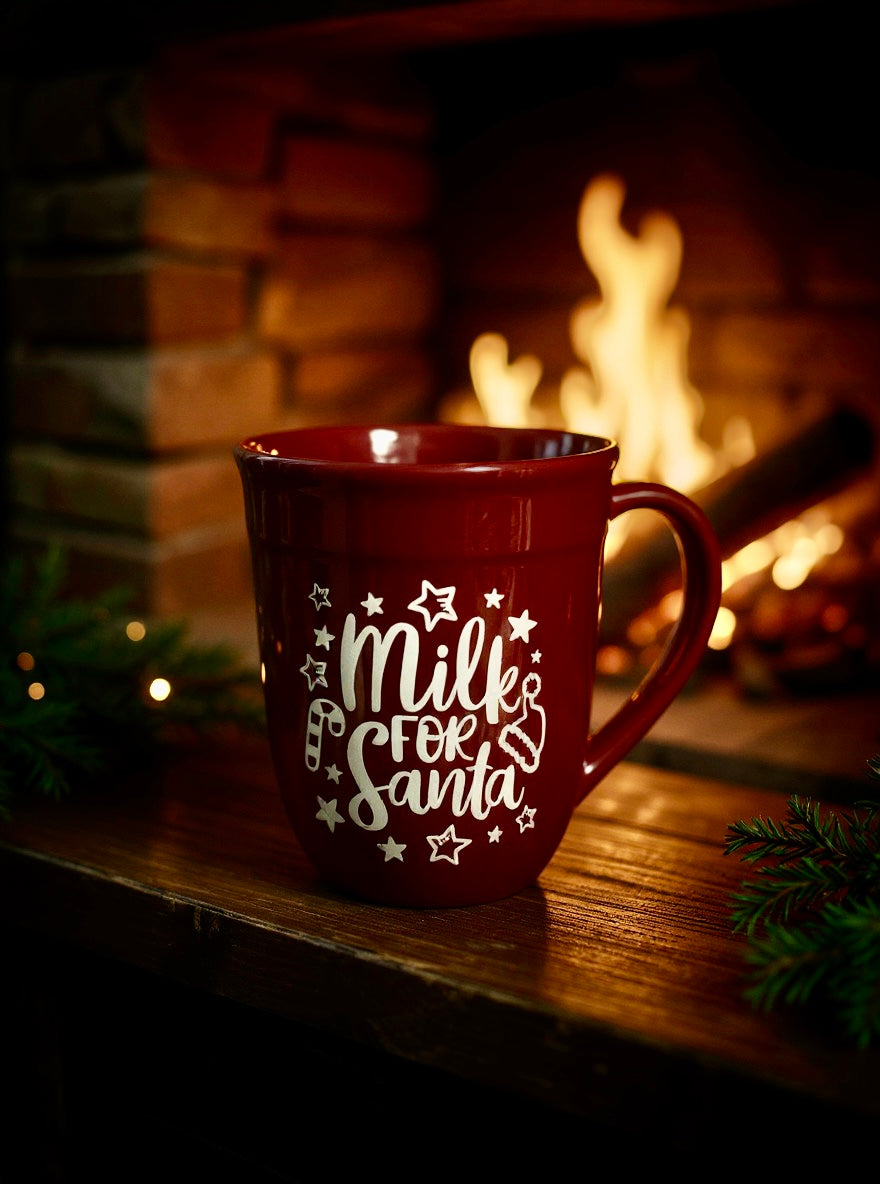 Red Milk for Santa mug with white lettering sitting near a fireplace
