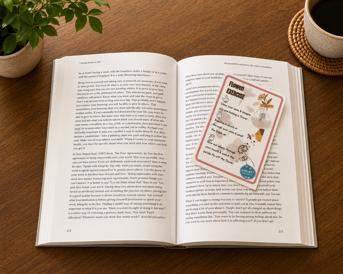 Mindfulness bookmark card featuring a flower breathing grounding exercise resting on an open book beside a cup of coffee