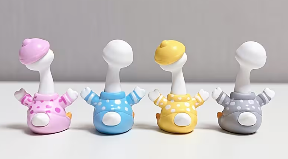 Back view of miniature resin geese wearing colorful polka-dot pajamas