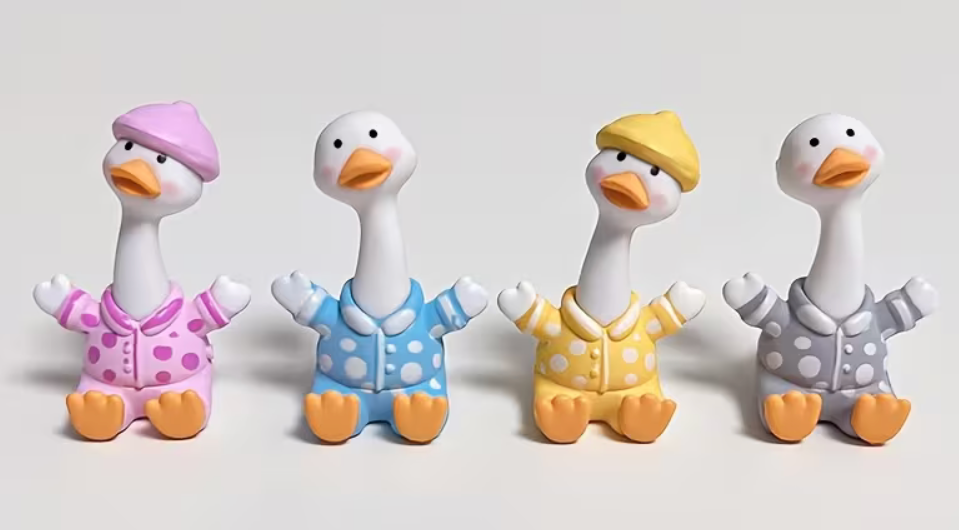 Assorted miniature pajama goose resin figurines in pink blue yellow and gray