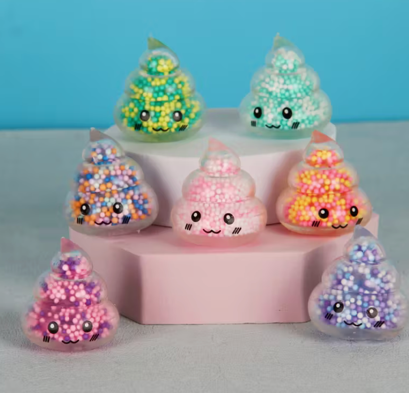 Mini colorful poop-shaped squishy fidget toy filled with tiny foam beads and featuring a smiling kawaii face.