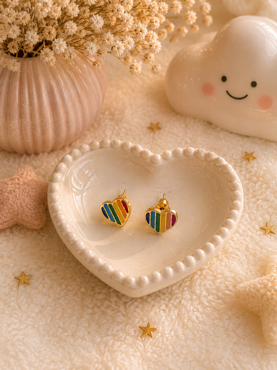 Minimalist rainbow heart stud earrings with colorful enamel stripes displayed in ceramic heart-shaped dish