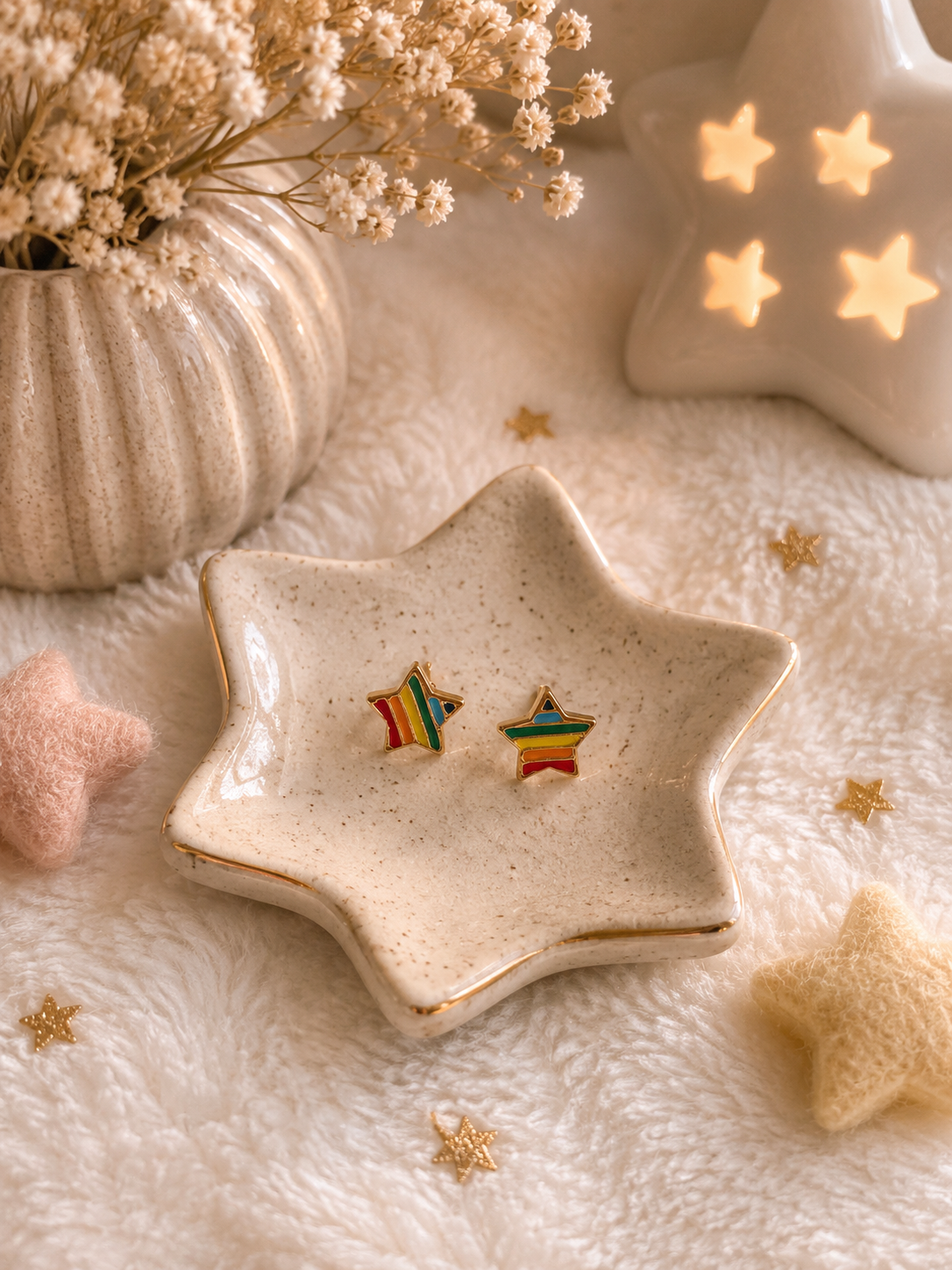 Minimalist rainbow star stud earrings displayed on ceramic star-shaped trinket dish with cozy neutral decor