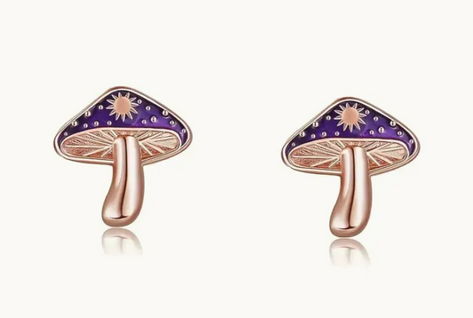 Mushroom-shaped earrings with purple caps and rose gold bodies on a white background