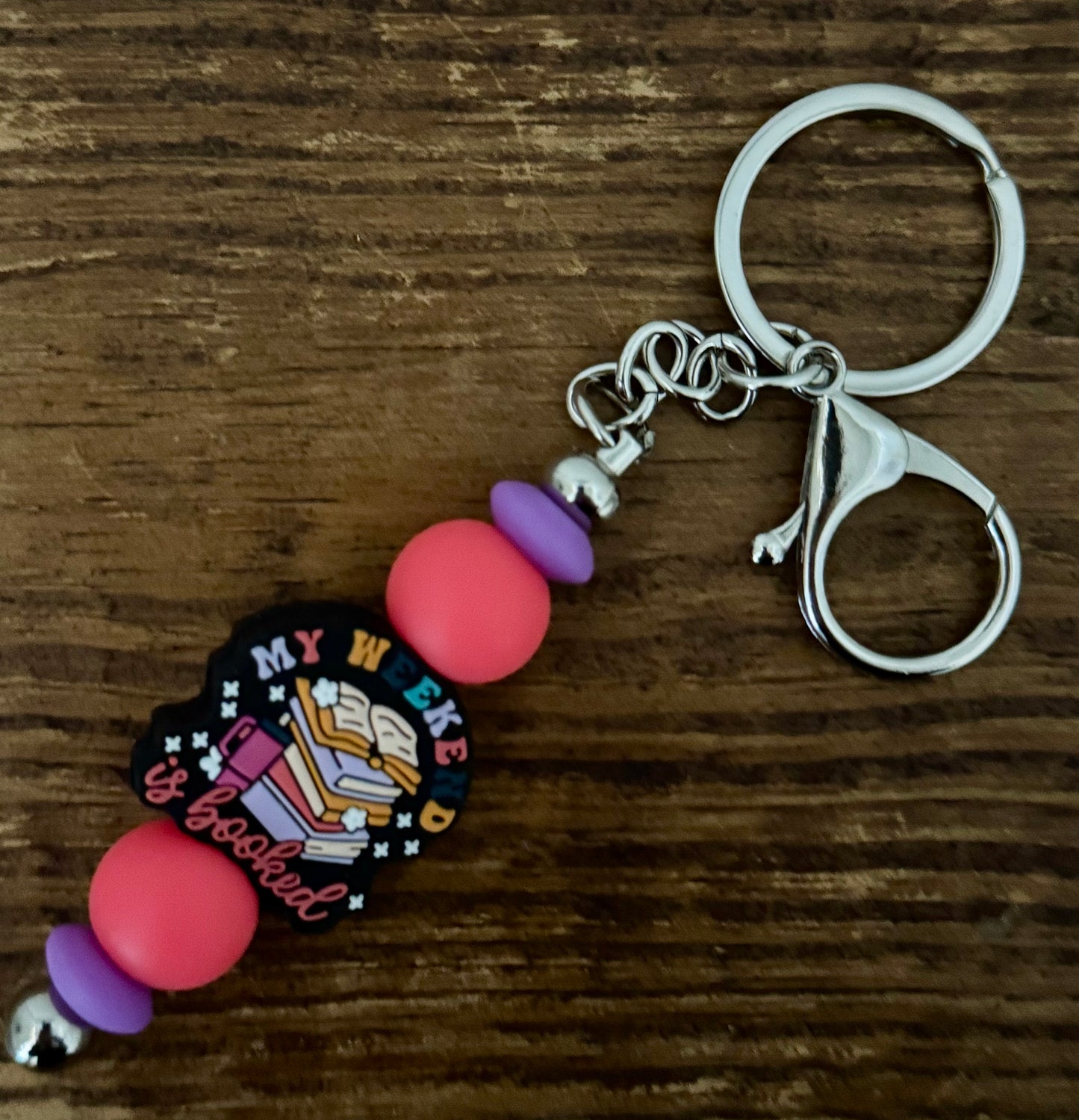 Keychain with colorful beads and a decorative tag on a wooden surface
