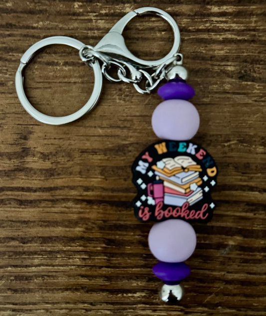 Keychain with beads and a decorative charm on a wooden surface