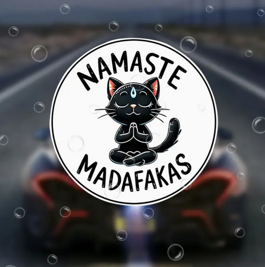 Sticker with a black cat illustration and text 'Namaste Madafakas' on a blurred background.