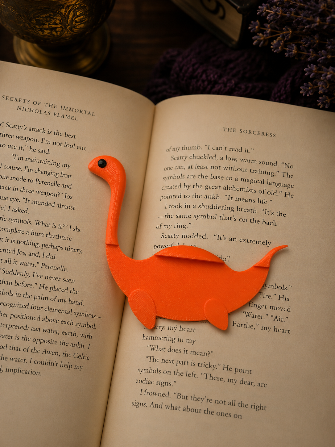 Orange dinosaur-shaped bookmark on an open book