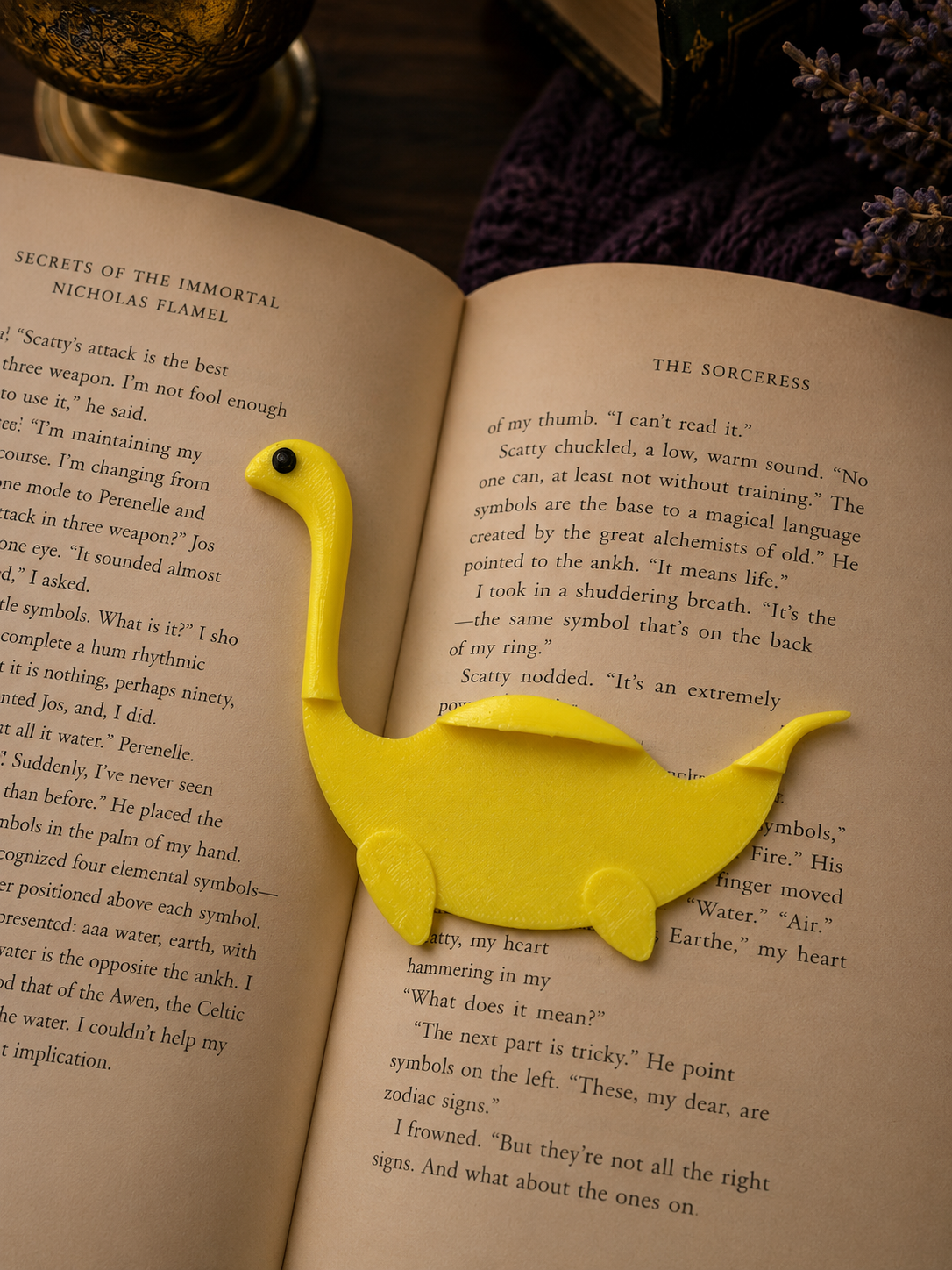 Yellow dinosaur-shaped bookmark on an open book with a blurred background