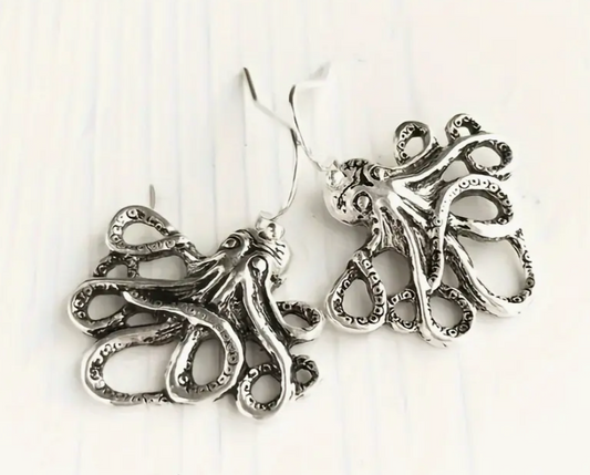 Silver octopus-shaped earrings on a white background
