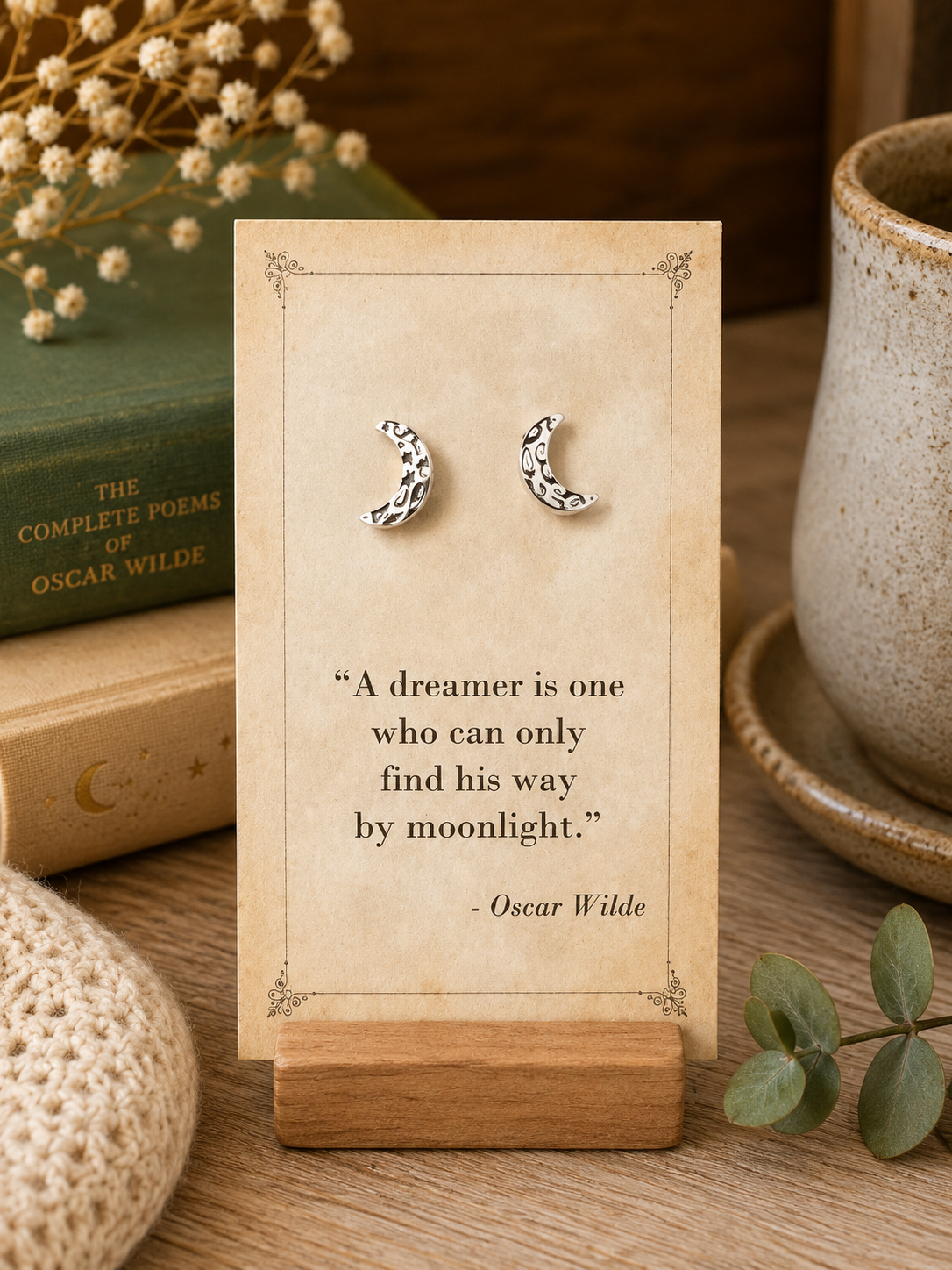 Silver tone patterned crescent moon stud earrings displayed on a vintage Oscar Wilde literary quote card