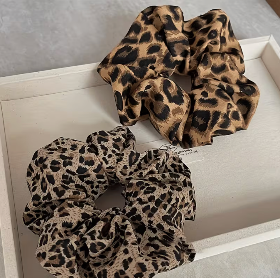 Two oversized leopard print scrunchies in classic tan and neutral beige animal print