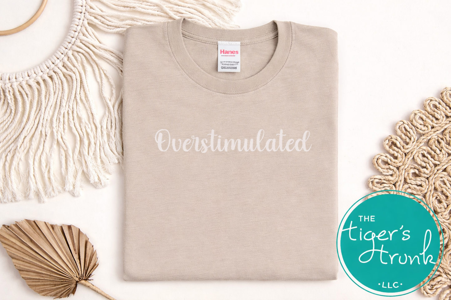 Beige t-shirt with 'Overstimulated' text on a white background with decorative elements.