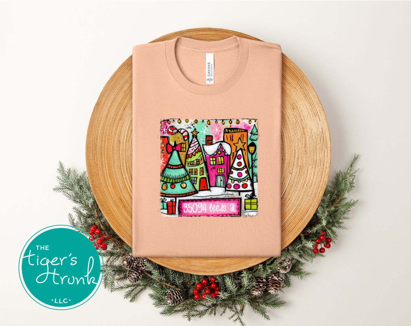 Peach Christmas shirt with pastel houses, holiday trees, and the zip code 35094 Leeds AL.